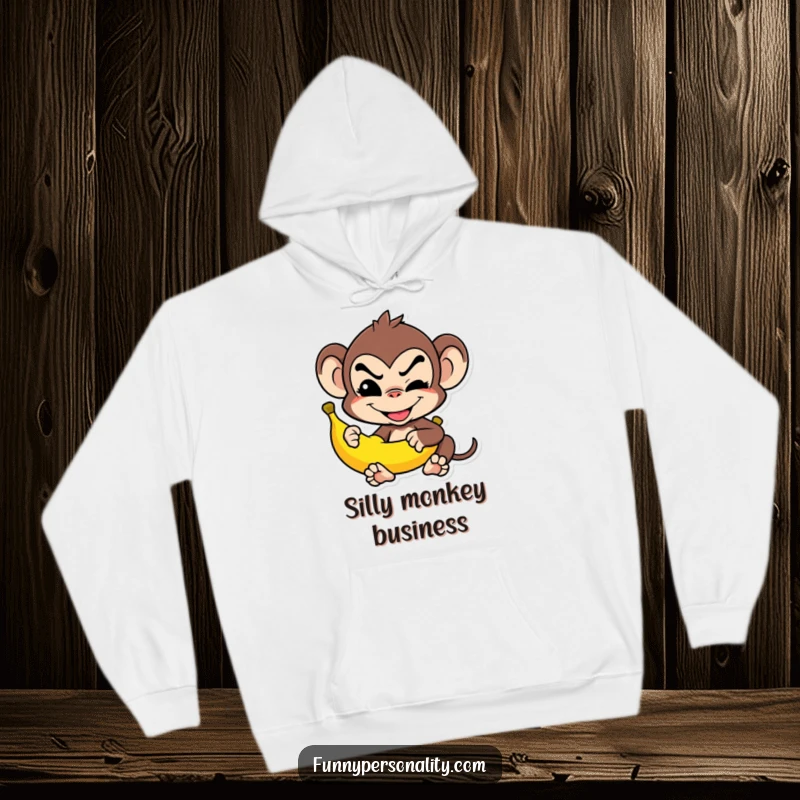 Funny Hoodie: A mischievous monkey grins while balancing a banana, perfect for cozy humor as a gift.