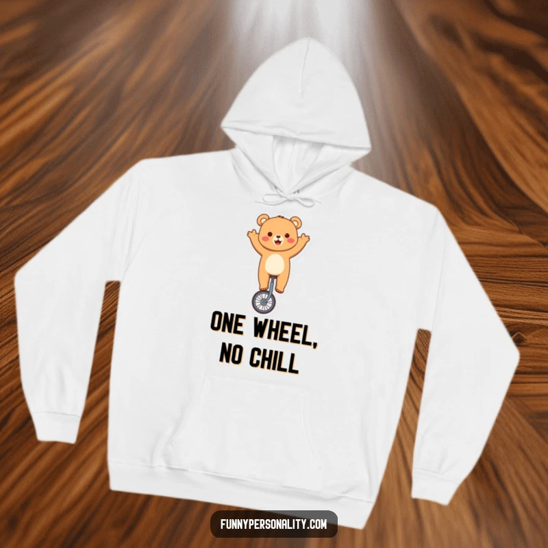 Funny bear hoodie showing a cute character skillfully balancing on a unicycle, waving joyfully, perfect for cozy humor.